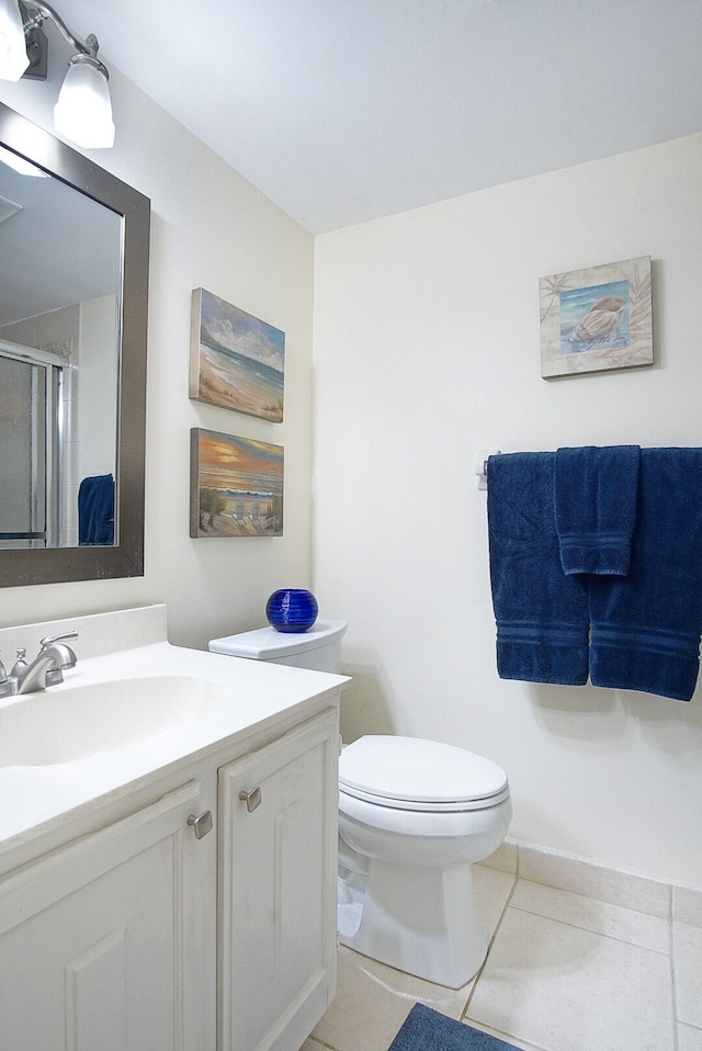 bathroom featuring tile patterned flooring, vanity, a shower with door, and toilet