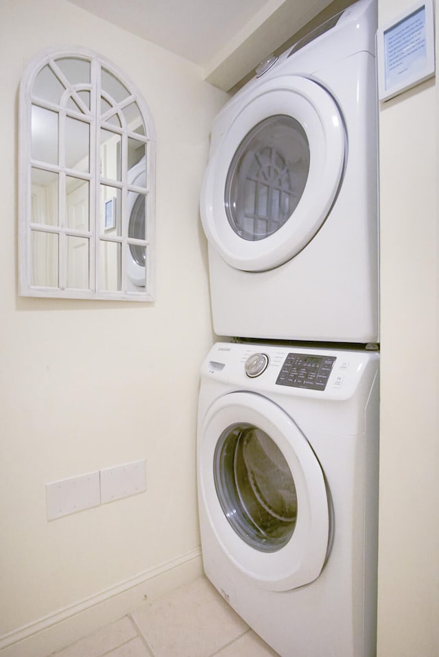 clothes washing area with tile patterned floors and stacked washing maching and dryer