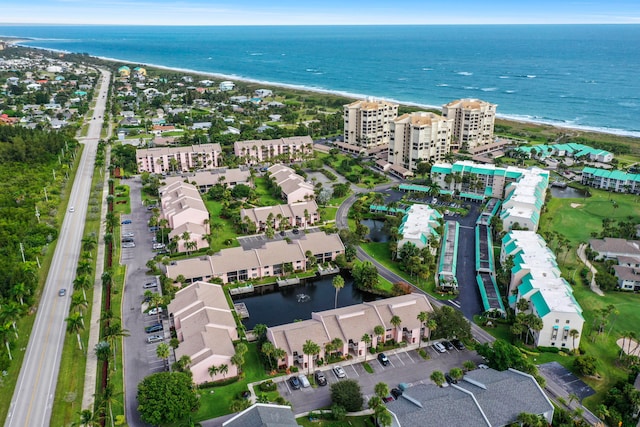 aerial view with a water view and a beach view