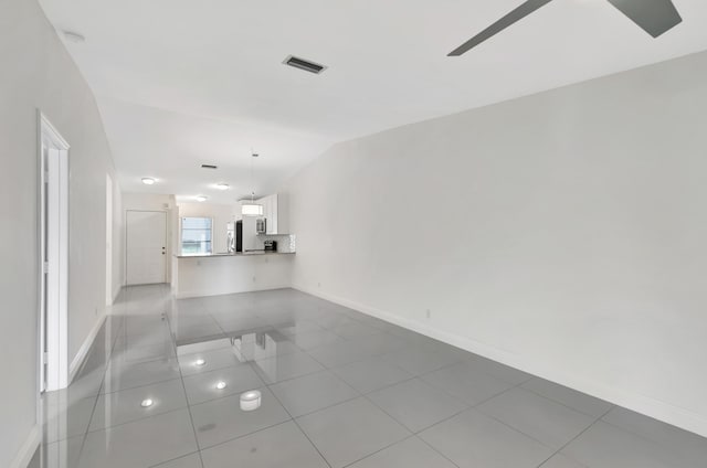 spare room with light tile patterned flooring and vaulted ceiling