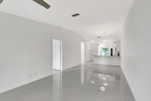 unfurnished room featuring vaulted ceiling and light tile patterned floors