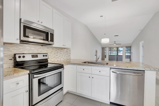 kitchen featuring lofted ceiling, kitchen peninsula, appliances with stainless steel finishes, and sink