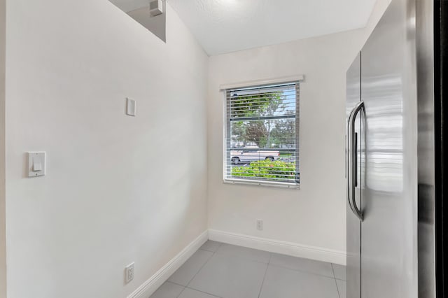 laundry area featuring a textured ceiling and light tile patterned floors