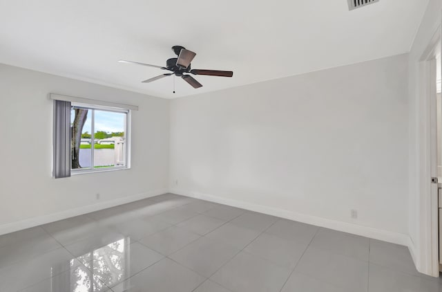 tiled spare room with ceiling fan