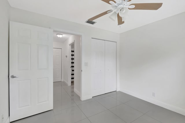 unfurnished bedroom featuring ceiling fan, tile patterned flooring, and a closet