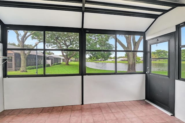 unfurnished sunroom featuring a water view and lofted ceiling with beams