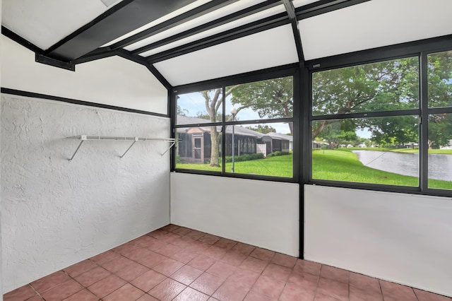 unfurnished sunroom featuring beamed ceiling