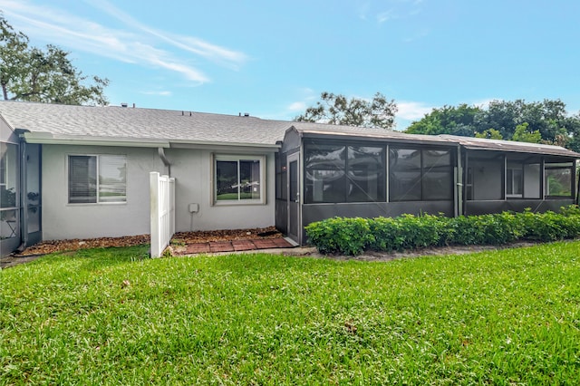 back of property featuring a sunroom and a yard