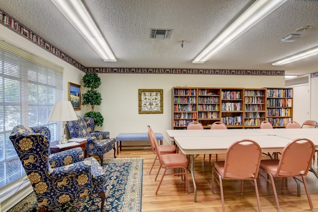 dining room featuring wood-type flooring and a textured ceiling