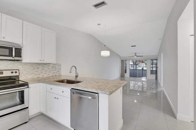 kitchen featuring lofted ceiling, stainless steel appliances, white cabinets, sink, and kitchen peninsula