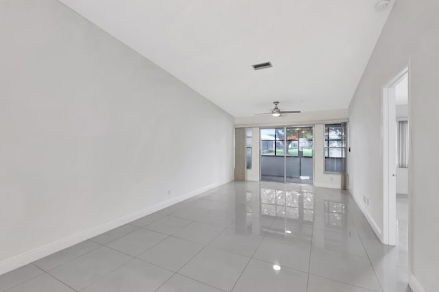 spare room with ceiling fan, vaulted ceiling, and light tile patterned floors