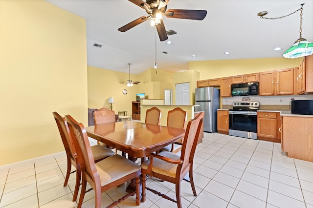 dining space with ceiling fan, lofted ceiling, and light tile patterned floors