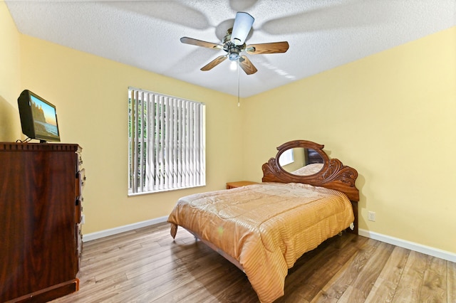 bedroom featuring a textured ceiling, light hardwood / wood-style flooring, and ceiling fan