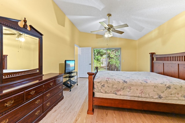 bedroom featuring a textured ceiling, light hardwood / wood-style floors, ceiling fan, and lofted ceiling