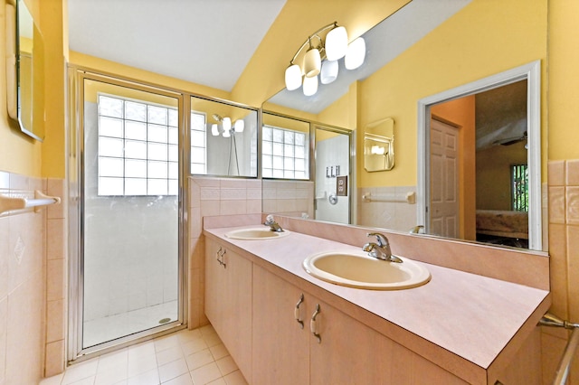 bathroom with tile patterned floors, vanity, an enclosed shower, and tile walls