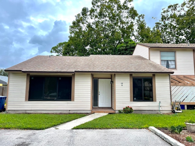 view of front of home with a wooden deck and a front yard