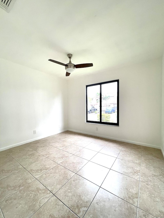 tiled spare room with ceiling fan