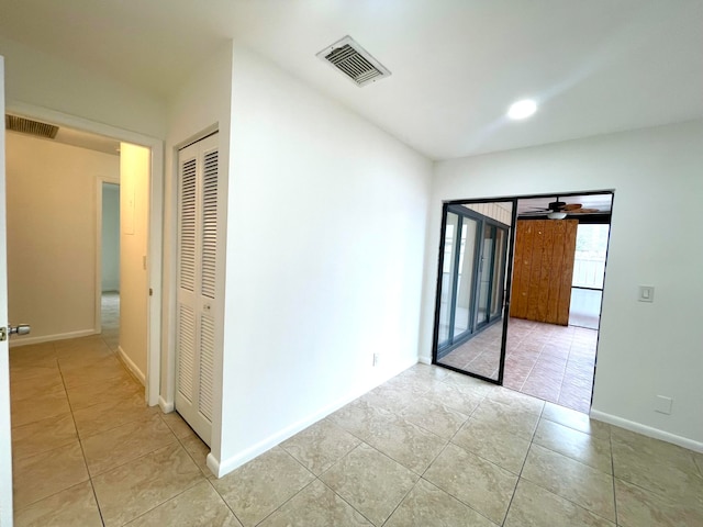 tiled empty room with ceiling fan