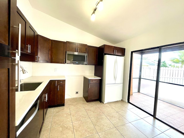 kitchen featuring light tile patterned floors, stainless steel appliances, sink, and lofted ceiling