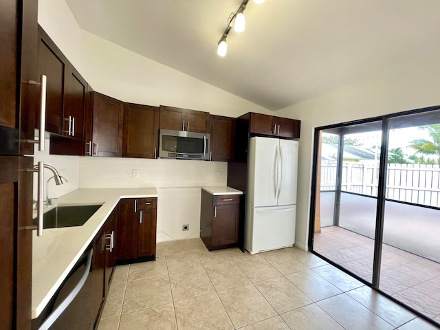 kitchen featuring lofted ceiling, sink, light tile patterned floors, and white refrigerator