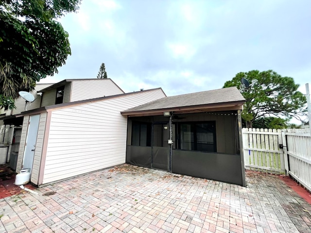 rear view of property featuring a sunroom and a patio area