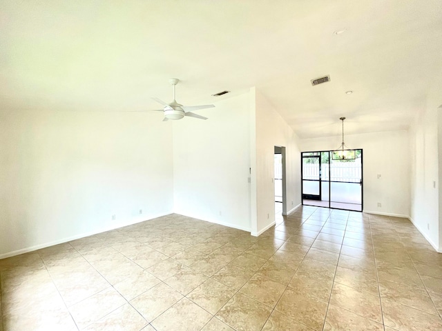 tiled empty room featuring ceiling fan with notable chandelier and lofted ceiling