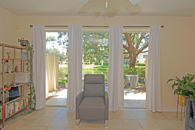 living area featuring ceiling fan, plenty of natural light, and light tile patterned flooring