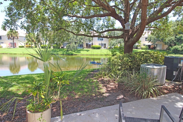 view of yard featuring a water view and central AC