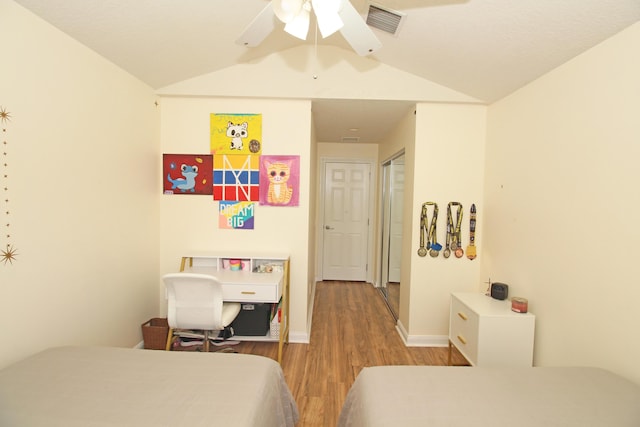 bedroom featuring a closet, ceiling fan, light hardwood / wood-style flooring, and vaulted ceiling