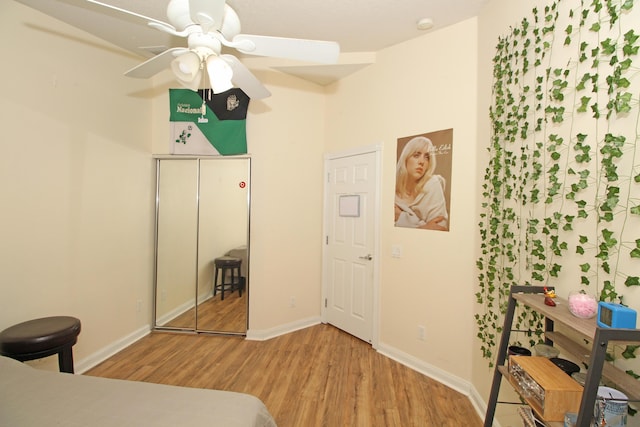 bedroom with hardwood / wood-style floors, ceiling fan, and a closet