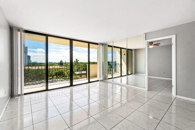 empty room with floor to ceiling windows and ceiling fan