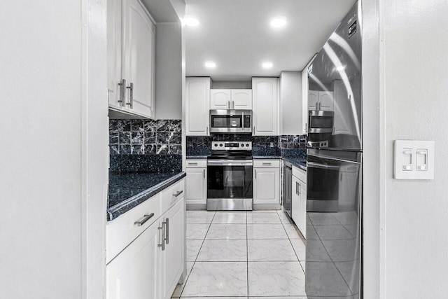 5600 N Flagler Dr Unit 505, West Palm Beach, FL 33407 - kitchen featuring decorative backsplash, marble finish floor, white cabinetry, dark countertops, and appliances with stainless steel finishes