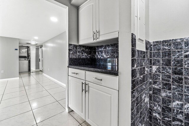 kitchen featuring white cabinets and washer / dryer