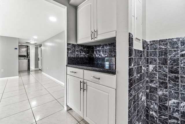 5600 N Flagler Dr Unit 505, West Palm Beach, FL 33407 - kitchen with dark countertops, stove, white cabinetry, and decorative backsplash