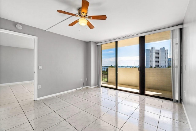 empty room featuring a wall of windows and ceiling fan