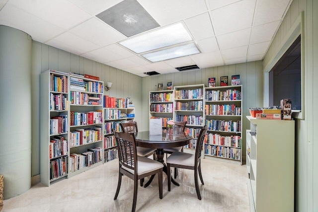 home office featuring wooden walls and a paneled ceiling