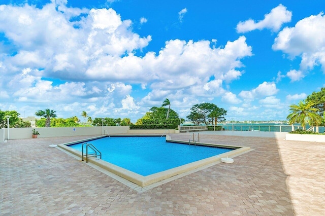 view of swimming pool featuring a water view