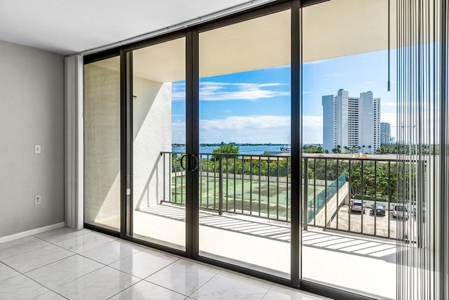 doorway to outside with a water view and a wall of windows