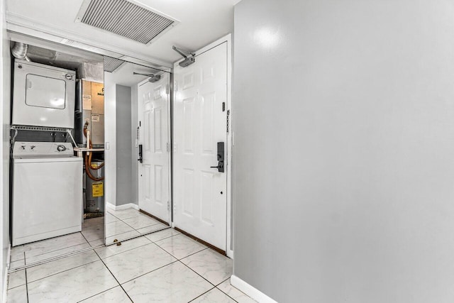 clothes washing area with stacked washer and clothes dryer