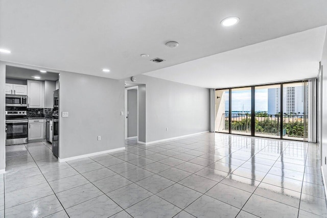 5600 N Flagler Dr Unit 505, West Palm Beach, FL 33407 - unfurnished living room featuring recessed lighting, light tile patterned floors, a wall of windows, baseboards, and visible vents