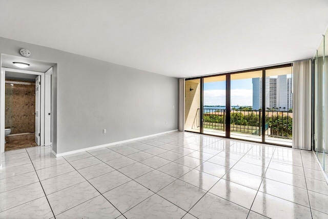 5600 N Flagler Dr Unit 505, West Palm Beach, FL 33407 - tiled empty room featuring floor to ceiling windows and baseboards