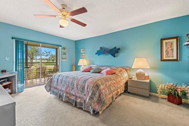 carpeted bedroom with ceiling fan, access to exterior, and a textured ceiling