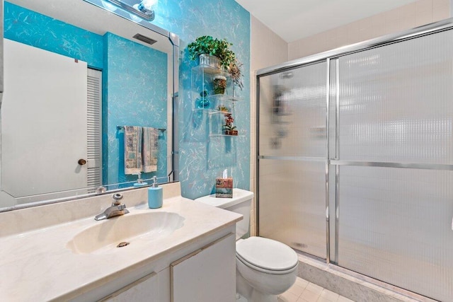 bathroom featuring tile patterned flooring, a shower with door, vanity, and toilet