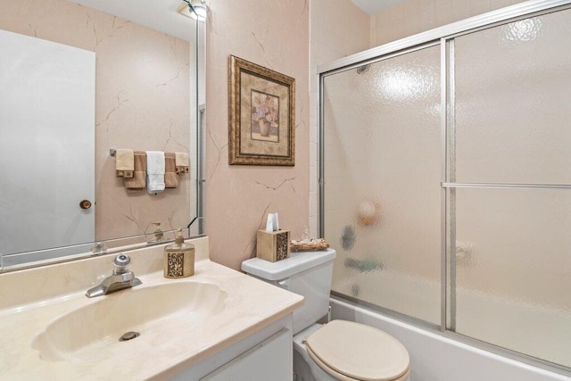 full bathroom featuring shower / bath combination with glass door, vanity, and toilet