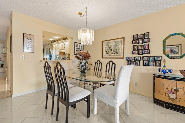 tiled dining room featuring a chandelier and a textured ceiling