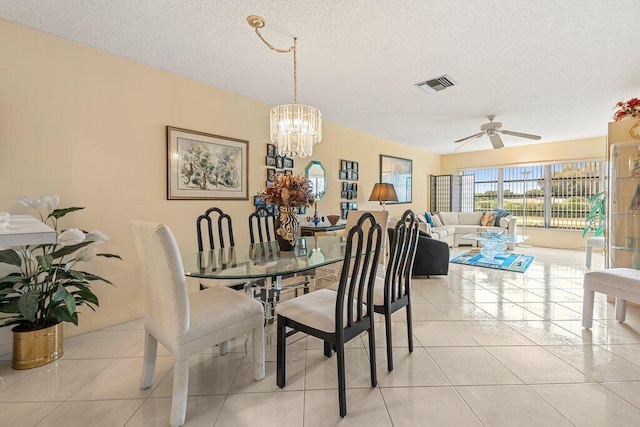 dining area featuring a textured ceiling, ceiling fan with notable chandelier, and light tile patterned flooring