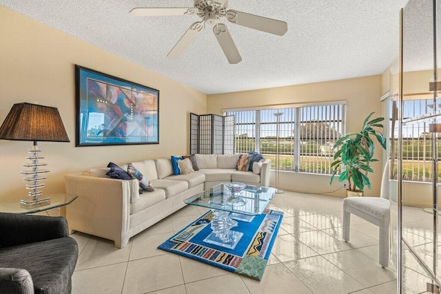 living room with ceiling fan, light tile patterned floors, and a textured ceiling