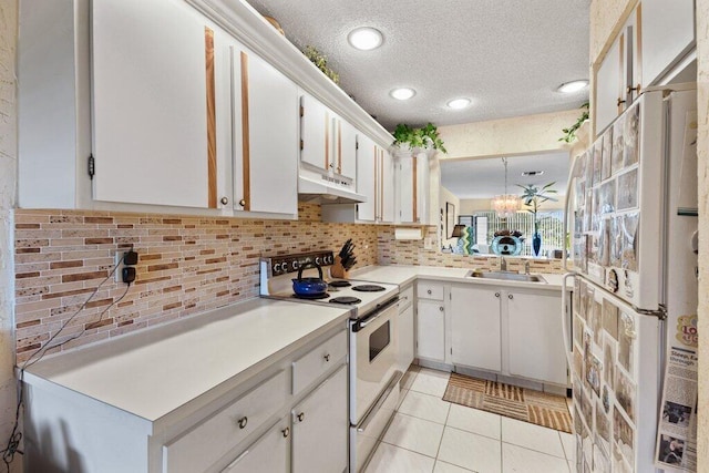 kitchen featuring white appliances, decorative light fixtures, and white cabinetry