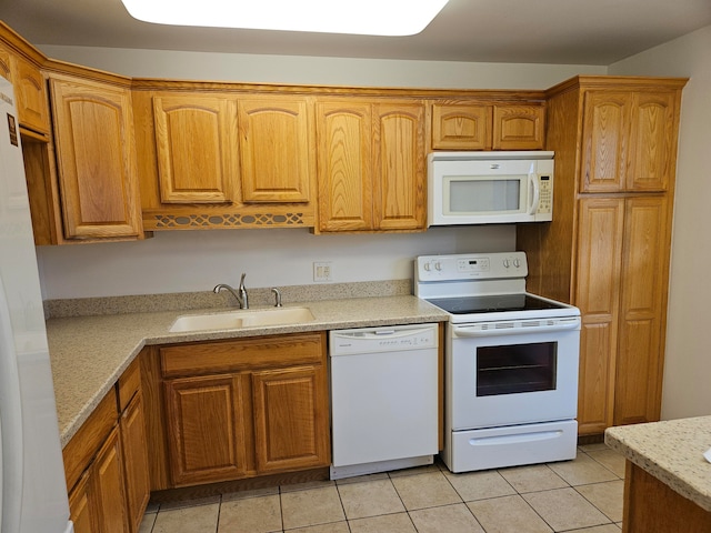 kitchen with light tile patterned floors, light stone countertops, sink, and white appliances