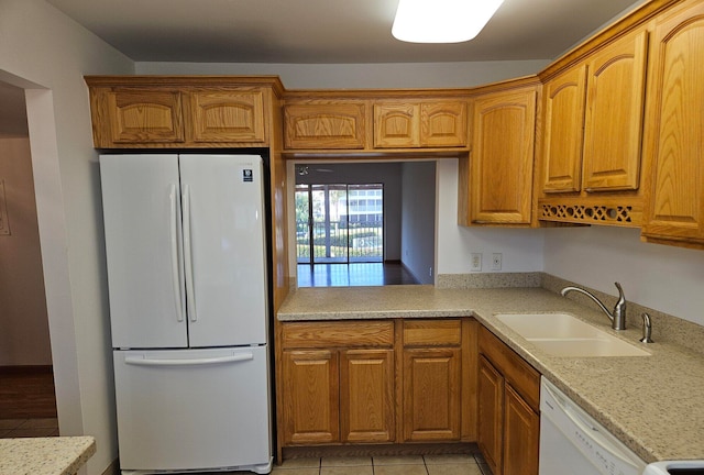 kitchen with light stone countertops, white appliances, sink, and light tile patterned floors